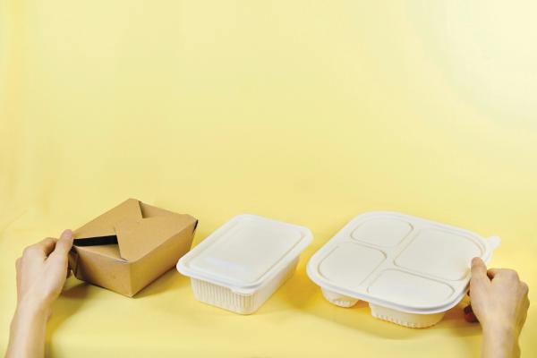 Yellow background with three types of packaging, in cardboard, paper and plastics