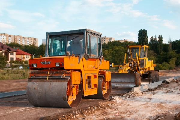 Image of a construction site on a street, with road rollers.